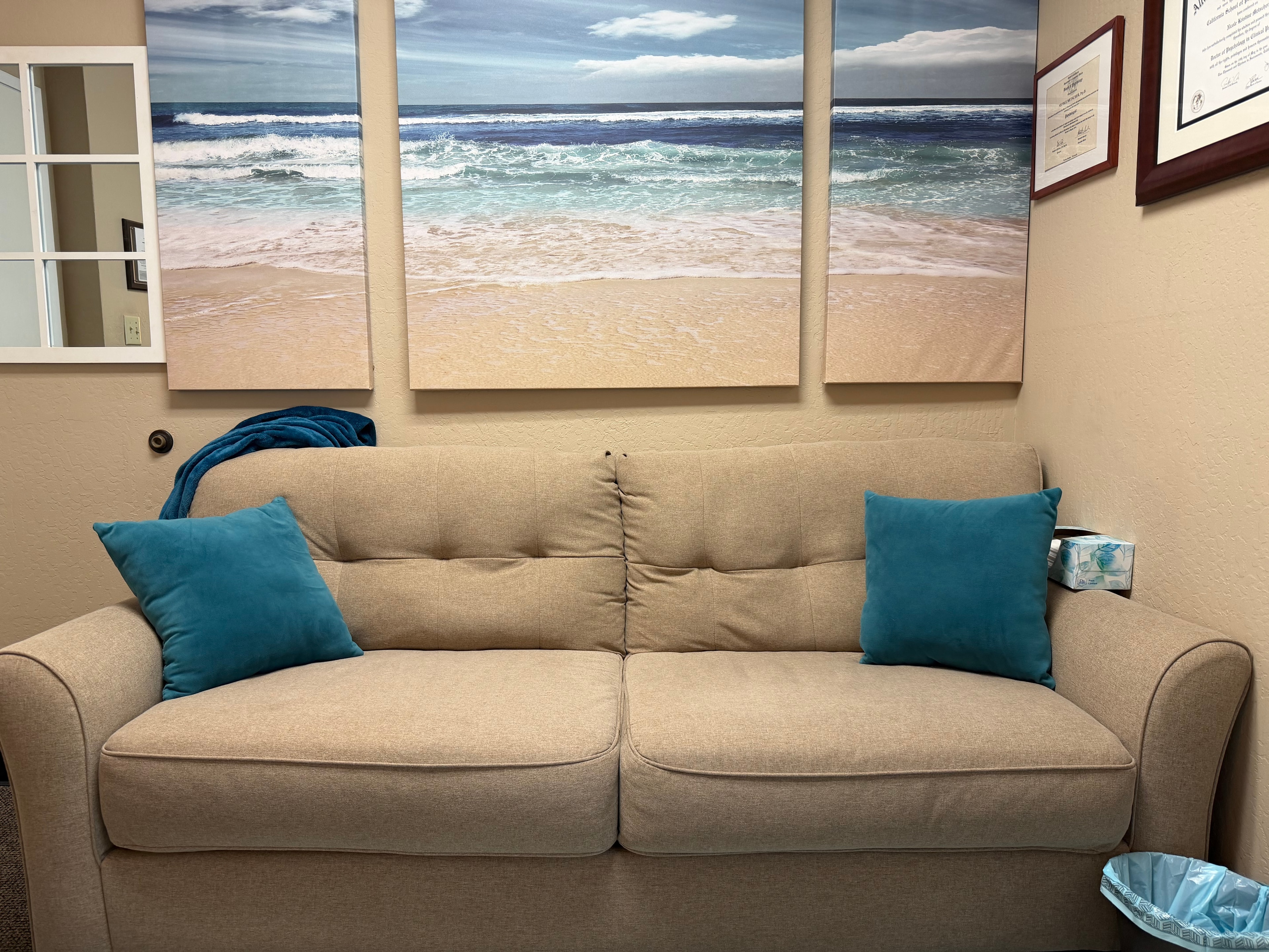 Comfortable waiting room sofa with coastal wall art